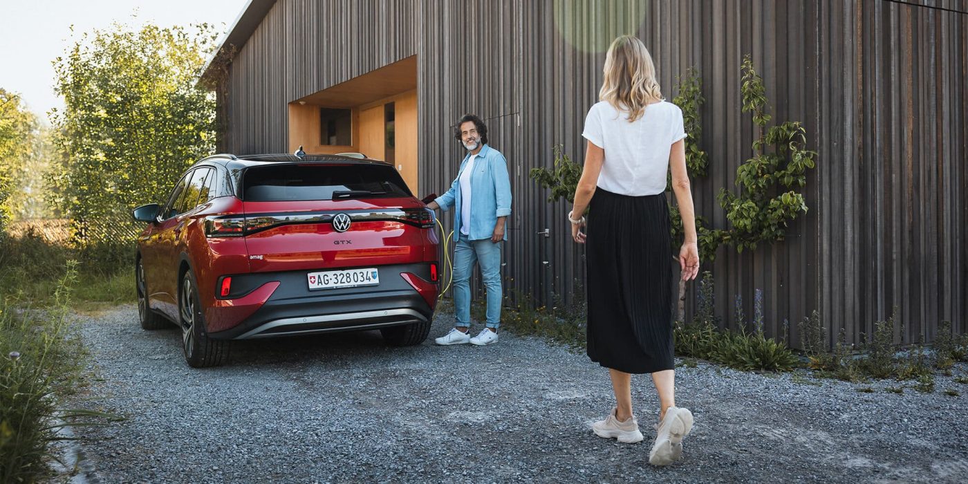 Junges Paar lädt Elektroauto VW ID.4 zuhause